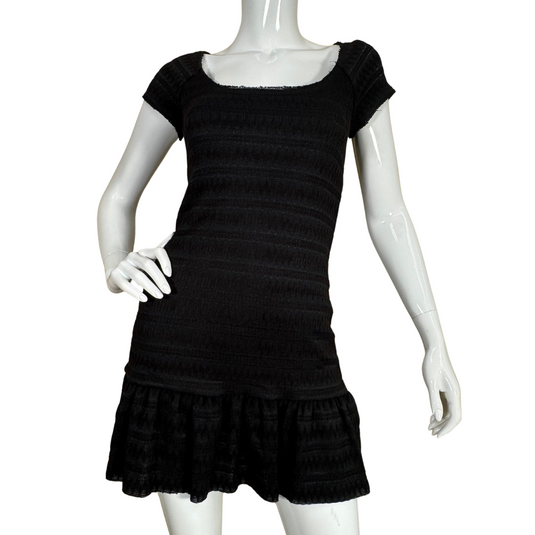 Free People Black Knit Mini Dress boasts a textured, subtly striped fabric with a smocked bodice that hugs the figure comfortably