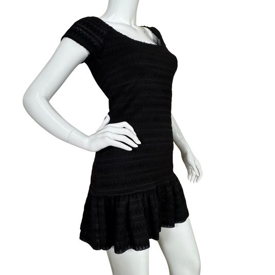 Free People Black Knit Mini Dress boasts a textured, subtly striped fabric with a smocked bodice that hugs the figure comfortably