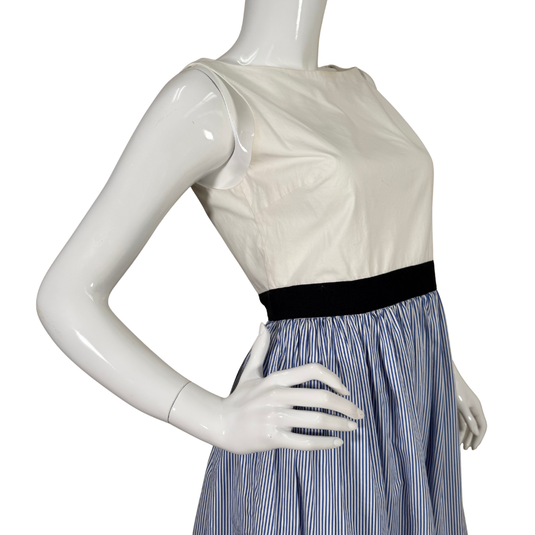 Mannequin wearing a white top with a black band and a blue striped skirt on a white background