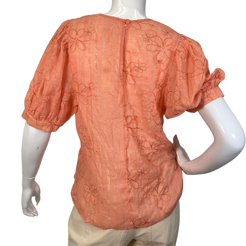 Load image into Gallery viewer, Amandi Orange Embroidered Blouse with Flowers is a women’s short-sleeve blouse in a warm orange color, featuring an embroidered floral design - backside view
