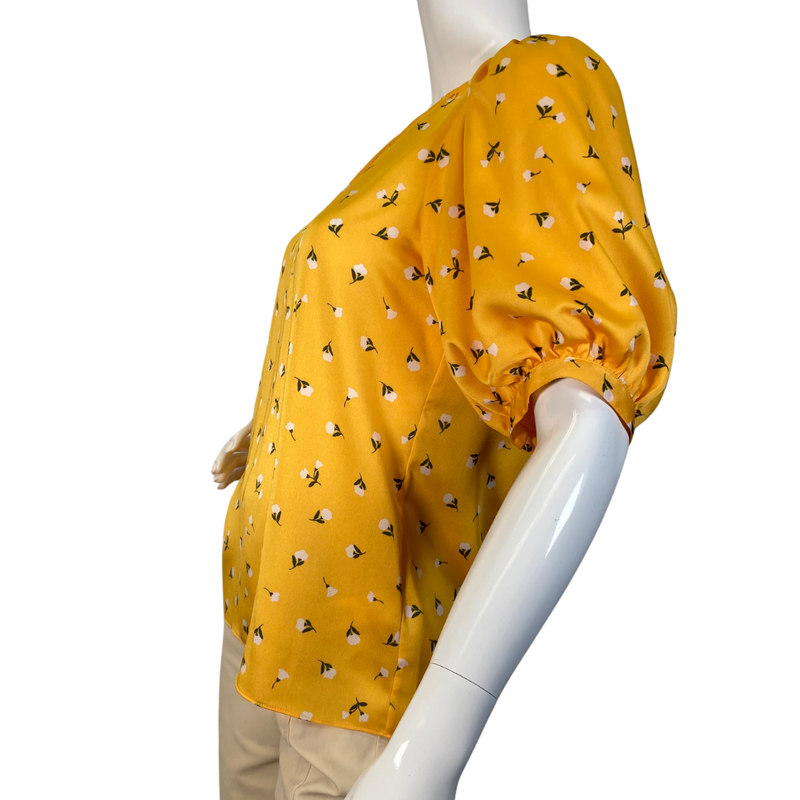 Load image into Gallery viewer,  Kate Spade Vibrant Yellow Blouse Featuring Small White Flowers is a cheerful, mustard-yellow blouse featuring a delicate floral print throughout - side view
