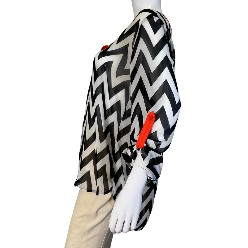 Load image into Gallery viewer, Vince Camuto Black and White Patterned Sheer blouse with Red Accents is a stylish women&#39;s tunic-style blouse with a bold black-and-white chevron print - side view
