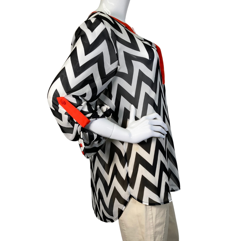 Load image into Gallery viewer, Vince Camuto Black and White Patterned Sheer blouse with Red Accents is a stylish women&#39;s tunic-style blouse with a bold black-and-white chevron print - side view
