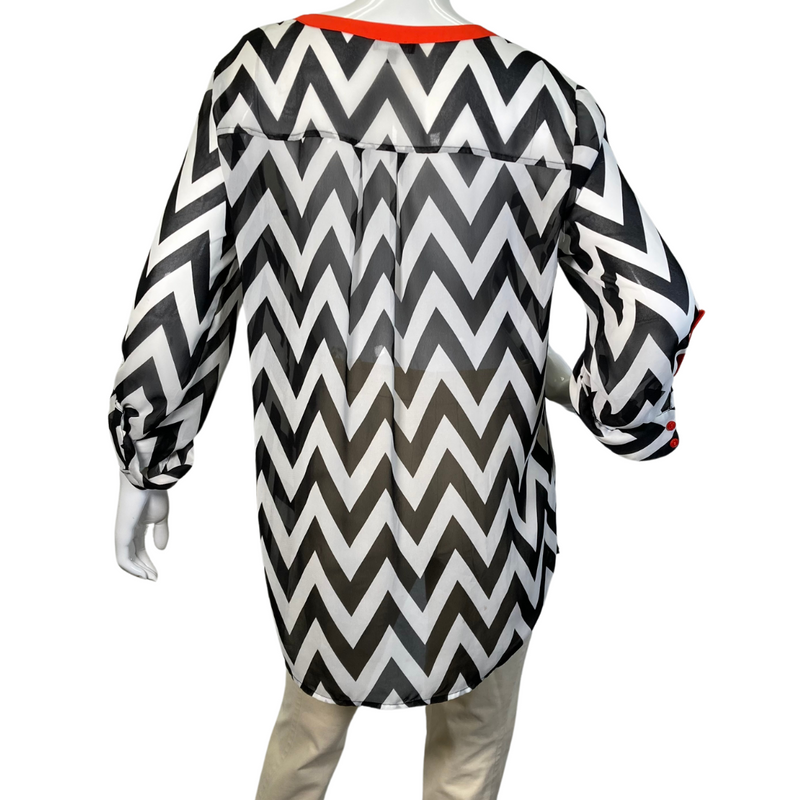 Load image into Gallery viewer, Vince Camuto Black and White Patterned Sheer blouse with Red Accents is a stylish women&#39;s tunic-style blouse with a bold black-and-white chevron print - backside view
