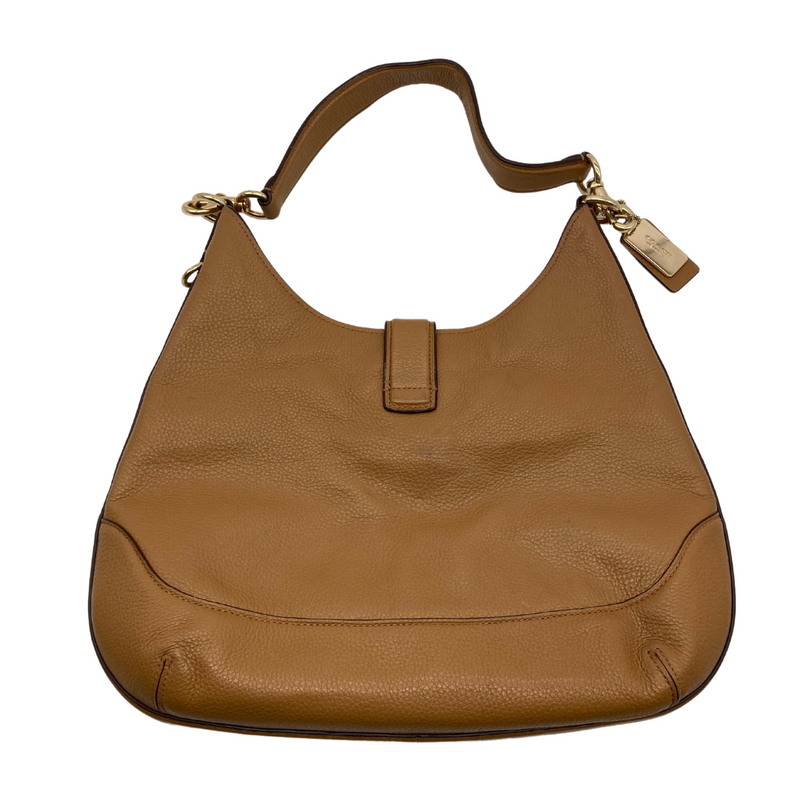 Load image into Gallery viewer, Coach Tan Leather Hobo Bag has a relaxed, slouchy silhouette. The bag features a wide adjustable shoulder strap with gold-tone hardware and clip attachments for a stylish, versatile look - backside view
