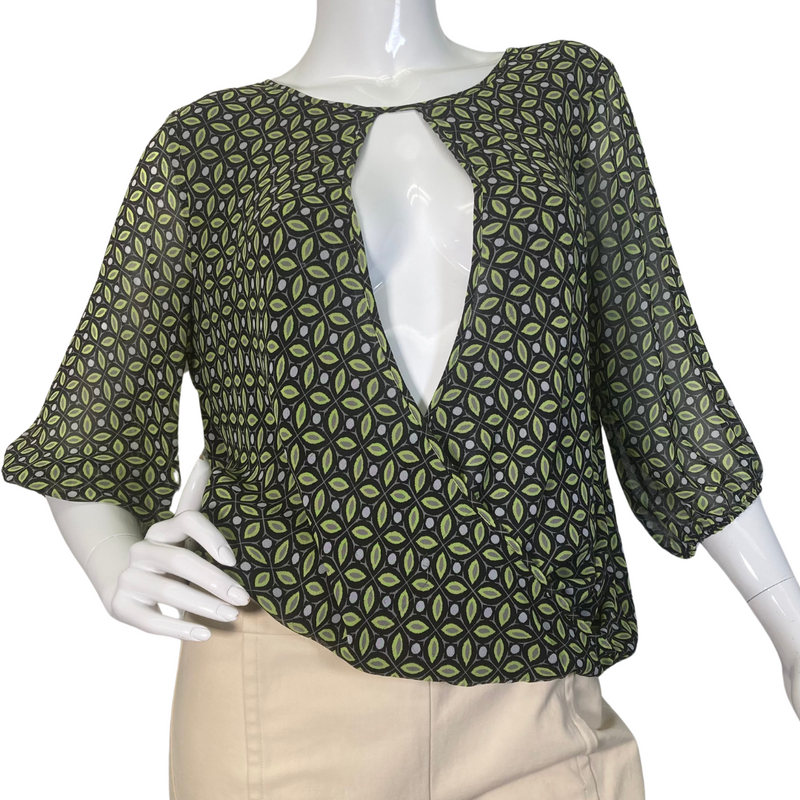 Load image into Gallery viewer, Vince Camuto Sheer Blouse with Opened V-shaped Cutout is a stylish women’s blouse featuring a unique geometric pattern in shades of green and black - front view
