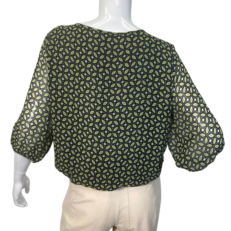 Load image into Gallery viewer, Vince Camuto Sheer Blouse with Opened V-shaped Cutout is a stylish women’s blouse featuring a unique geometric pattern in shades of green and black - backside view
