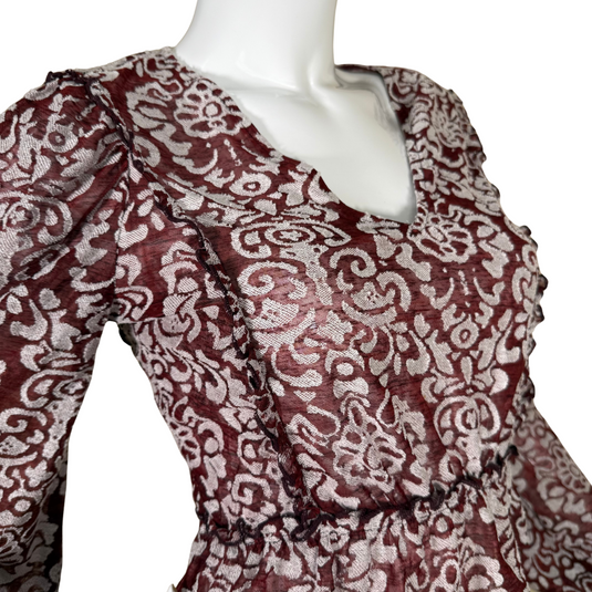 Make a stylish statement with this donated Anthropologie Sheer Burgundy Top with White Ornaments, adorned with a delicate silver damask pattern