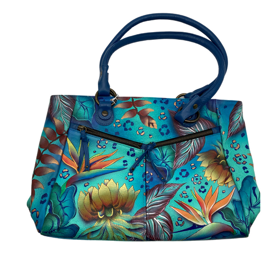 Anuschka Tropical Florals Blue Leather Shoulder Bag is a vibrant handbag features a stunning tropical-inspired design with a rich blue background adorned with colorful floral and foliage patterns