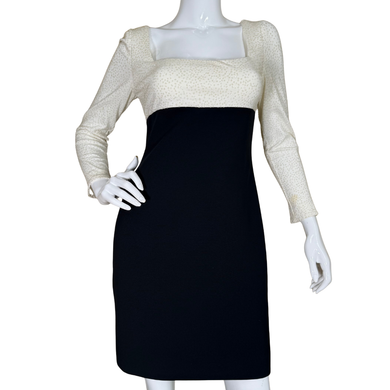 Mannequin wearing a black dress with a beige long-sleeve top on a white background