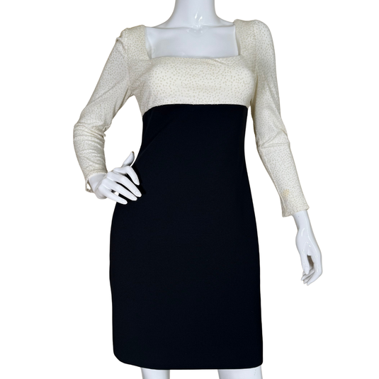 Mannequin wearing a black dress with a beige long-sleeve top on a white background