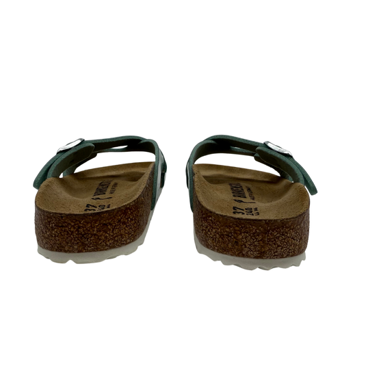 Pair of green sandals with cork soles on a white background