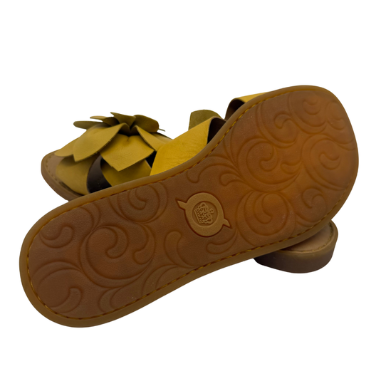 Pair of sandals with a textured brown sole on a white background
