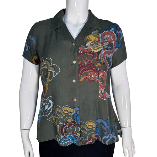 Mannequin wearing a dark green shirt with colorful dragon design on a white background