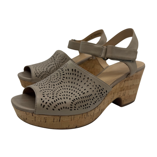 Pair of beige sandals with cork platform and heel on a white background