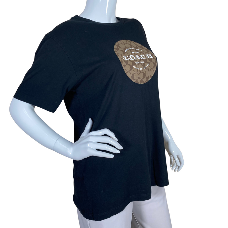 Load image into Gallery viewer, Coach Black Tee with Monogram is a black short-sleeve T-shirt featuring a Coach logo design on the front - side view
