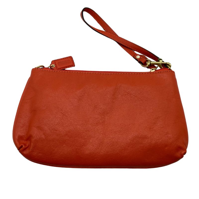 Load image into Gallery viewer, Coach Small Slim Orange Hand Purse in a orange red leather. It features a sleek and minimalistic design with a wrist strap for easy carrying.
