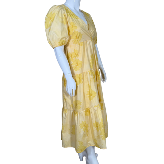 Yellow floral dress on a mannequin against a white background