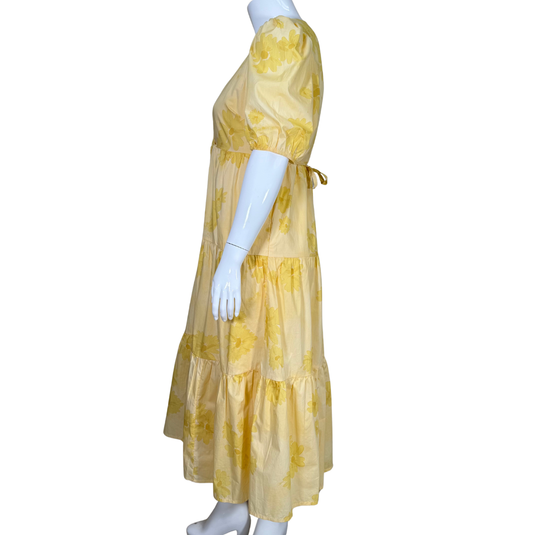Yellow floral dress on a mannequin against a white background