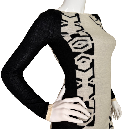 Mannequin wearing a black and beige patterned dress with long sleeves.