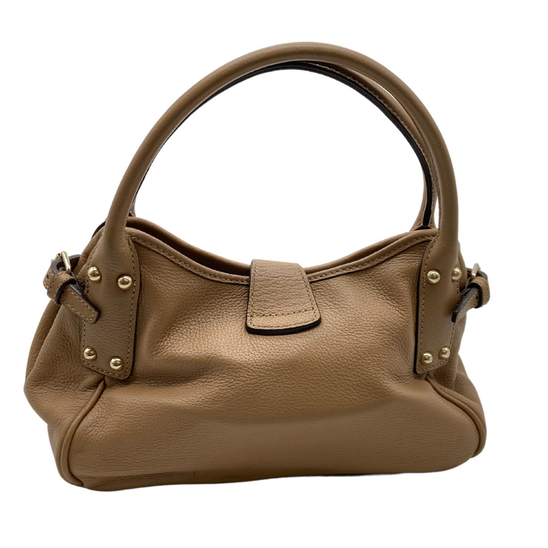 Load image into Gallery viewer, Pre-loved Dooney Bourke Light Brown Handbag is a stylish, medium-sized beige leather handbag with a pebbled texture. It features gold-tone hardware, including a decorative clasp on the front with an engraved logo and studded details on the handle attachments - backside view
