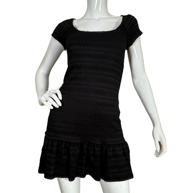 Free People Black Knit Mini Dress boasts a textured, subtly striped fabric with a smocked bodice that hugs the figure comfortably