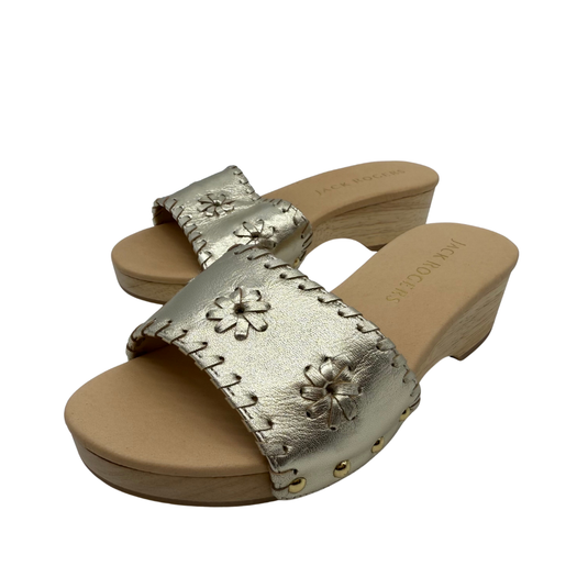 Gold sandals with floral designs on a white background