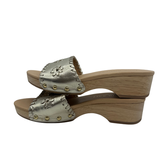 Wooden clog shoe with metallic silver upper and gold studs on a white background