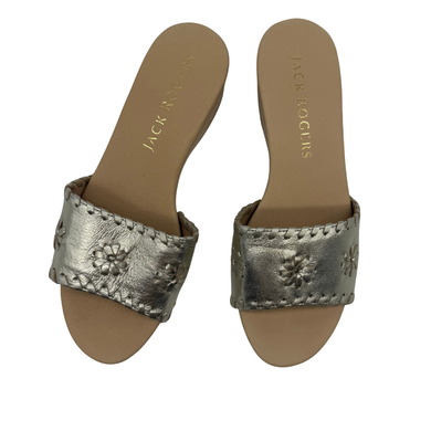 Pair of silver sandals with floral designs on a white background