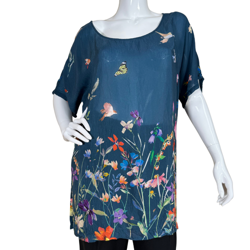 Mannequin wearing a blue dress with colorful floral and butterfly pattern on a white background
