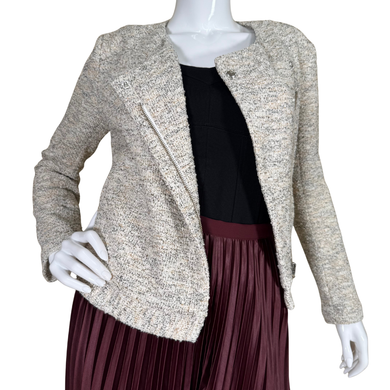 Mannequin wearing a beige textured jacket over a black top and maroon pleated skirt on a white background