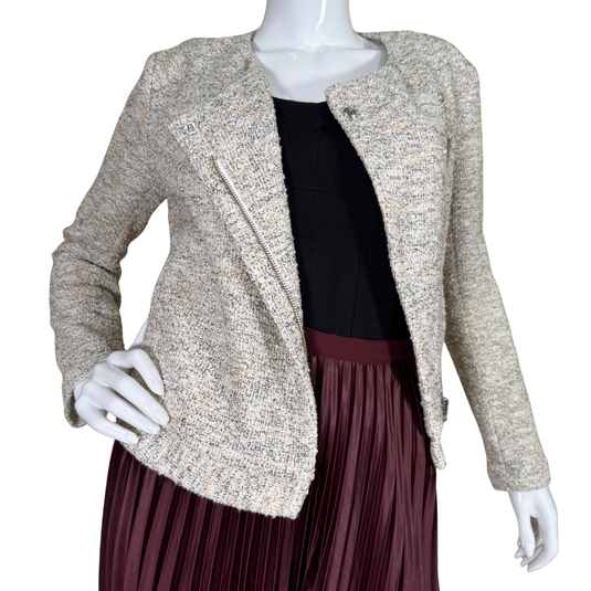 Mannequin wearing a beige textured jacket over a black top and maroon pleated skirt on a white background