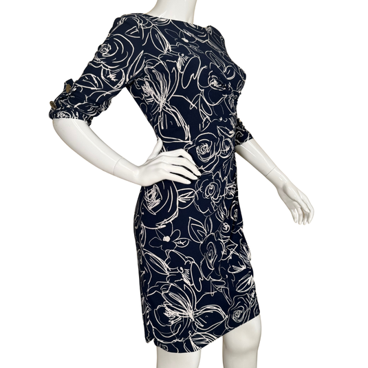 Navy dress with white floral pattern on a mannequin against a white background