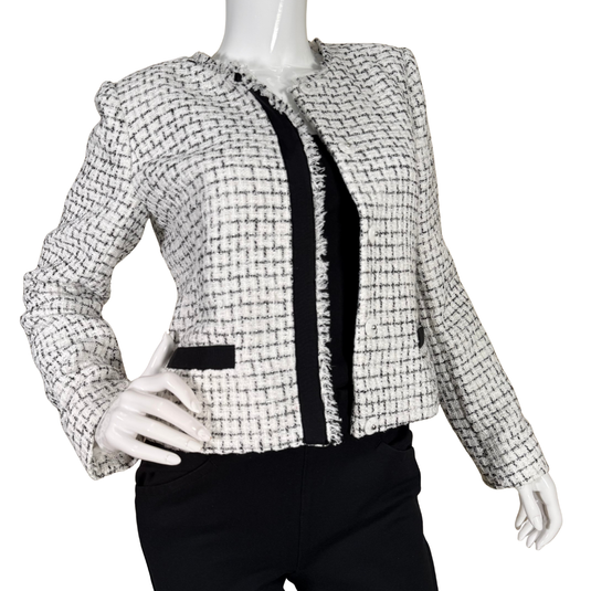 Tweed jacket with black accents on a mannequin against a white background
