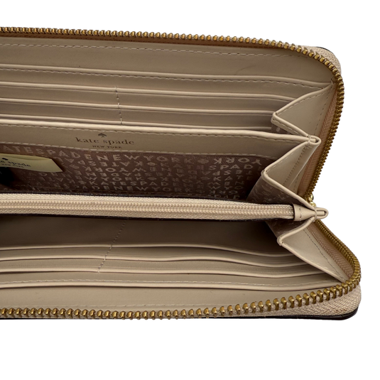Beige wallet with gold zipper and 'kate spade' branding on a white background
