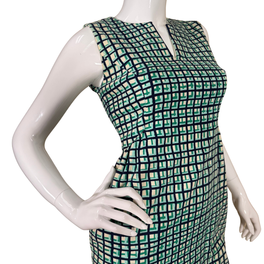 Mannequin wearing a green and black patterned dress on a white background