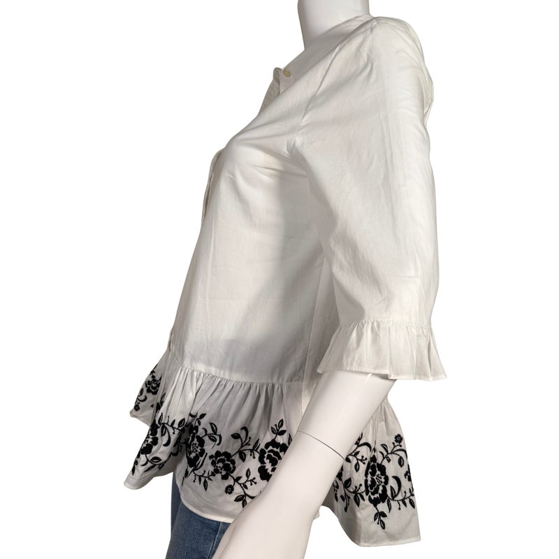 Load image into Gallery viewer, White blouse with black floral embroidery on a mannequin against a white background
