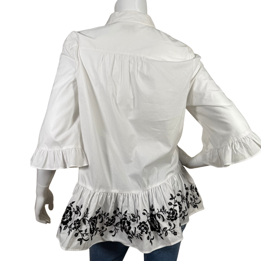 White blouse with ruffled sleeves and black embroidery on a white background