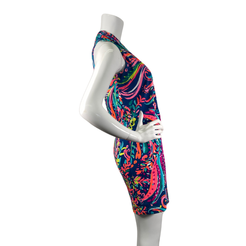 Load image into Gallery viewer,  Lilly Pultizer Psychedelic Neck Drop Cinched Waist Minidress is a vibrant, sleeveless dress with a colorful abstract pattern featuring shades of pink, green, yellow, and blue on a dark navy background - side view
