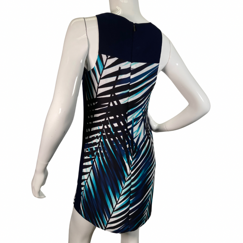 Load image into Gallery viewer, Trina Turk Shades of Blue Sleeveless Dress vibrant sleeveless shift dress showcases a striking tropical palm leaf pattern in shades of navy, teal, and white, evoking a fresh and breezy aesthetic backside view
