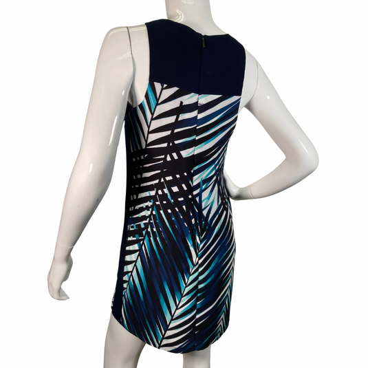 Trina Turk Shades of Blue Sleeveless Dress vibrant sleeveless shift dress showcases a striking tropical palm leaf pattern in shades of navy, teal, and white, evoking a fresh and breezy aesthetic backside view