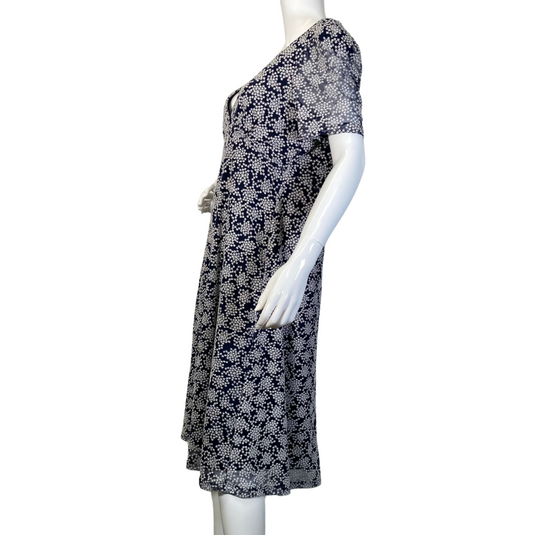 pre-loved Michael Kors Navy Blue Dress with Snowflake Pattern. It has short sleeves, a V-neckline, and a fitted bodice that flares into a slightly A-line skirt - side view