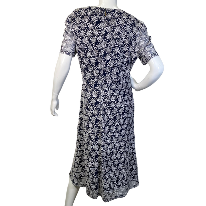 Load image into Gallery viewer, pre-loved Michael Kors Navy Blue Dress with Snowflake Pattern. It has short sleeves, a V-neckline, and a fitted bodice that flares into a slightly A-line skirt - backside view
