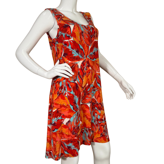 Mannequin wearing a sleeveless dress with a vibrant red and orange leaf pattern on a white background