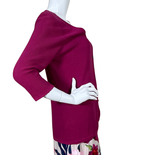 Mannequin wearing a magenta sweater with a white background