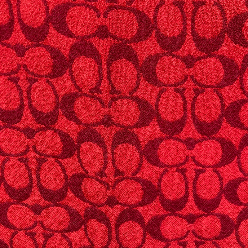 Load image into Gallery viewer, Coach Black and Red Monogram Scarf close up of the chic and intricate pattern of interlocking Coach monogram
