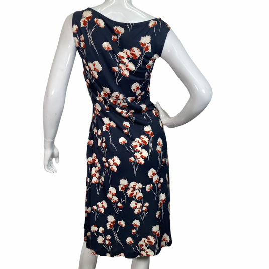 Tory Burch Delicate Floral Midi Dress is a beautiful sleeveless dress, featuring a navy blue base with floral print in white and rust hues - backside view