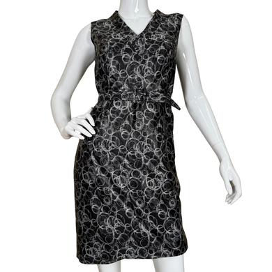 Black sleeveless dress with white floral pattern on a mannequin against a white background