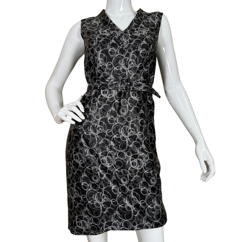 Black sleeveless dress with white floral pattern on a mannequin against a white background