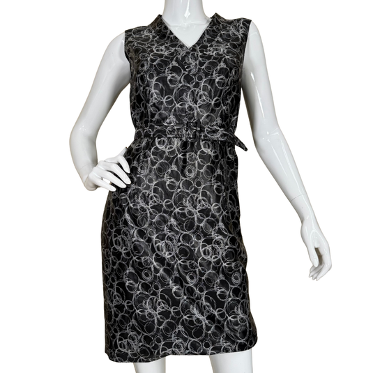 Black sleeveless dress with white floral pattern on a mannequin against a white background